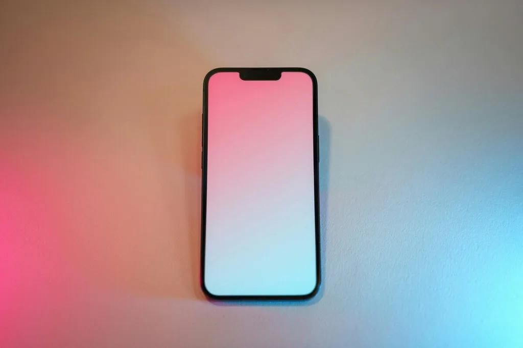 Celular sobre uma mesa com iluminação rosa e azul