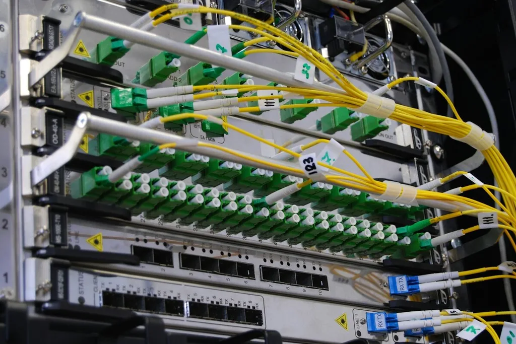 Cabos amarelos de fibra óptica conectados a equipamentos de rede