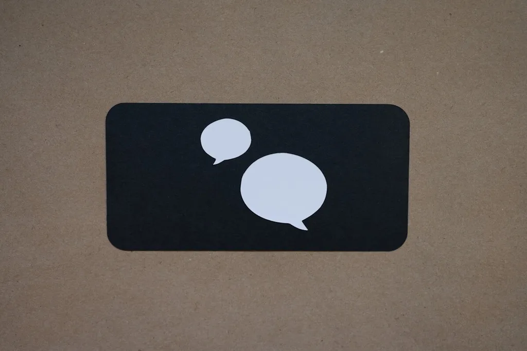 Pessoa revisando atendimento pelo celular com notebook aberto para CRM e automação comercial